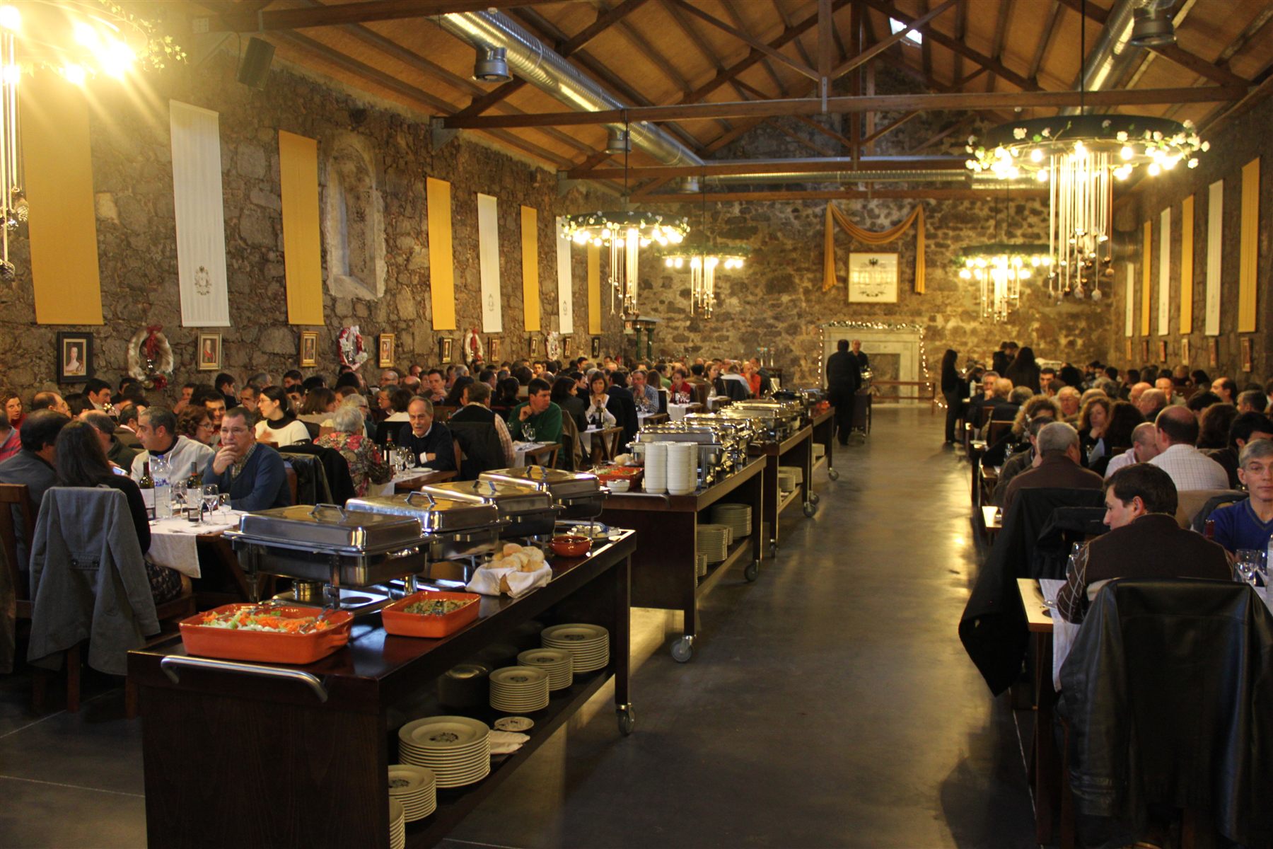 Guests dining in a large hall with stone walls