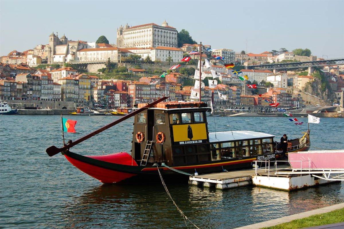 Rabelo boat on the Douro River with Porto in the background